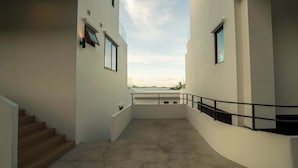 A modern building with a curved balcony, a staircase, and a view of the sky. - Staylar Seaview Pool Villa - Coral Cove, Koh Samui CC1 (Koh Samui, Coral Cove)