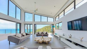 A spacious living room with large windows, a flat-screen TV, and a modern coffee table. - Staylar Luxury Seaview Pool Villa Maeva, Koh Samui (Koh Samui, Chaweng Noi)