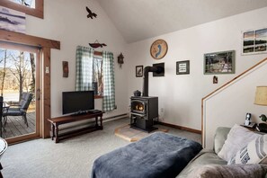 A cozy living room with a TV, a fireplace, and a sofa.