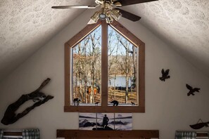 A room with a large window, wooden beams, and wall-mounted animal carvings. - Lakefront w Water Toys, Deck, Fire Pit & Grill (Springfield)