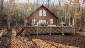 Une cabane dotée d’une terrasse, de grandes fenêtres et d’un escalier menant à celle-ci.