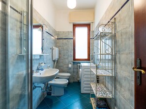 Une petite salle de bain comprenant un lavabo, des toilettes et une douche.