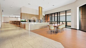 A spacious, modern hotel lobby with a central island, seating area, and large windows.