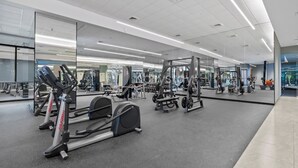 A gym with cardio equipment, weight machines, and mirrors on the walls.