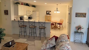 A compact living space with a kitchenette, a dining area, and a seating area with a sofa and chairs.