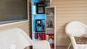 A compact kitchenette with a coffee maker, storage containers, and a variety of beverages.