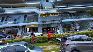 Un grattacielo con diversi piani, con un cartello ben visibile che riporta 'NEU SUITES'.