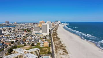 A coastal cityscape with a beachfront, high-rise buildings, and a clear blue sky.