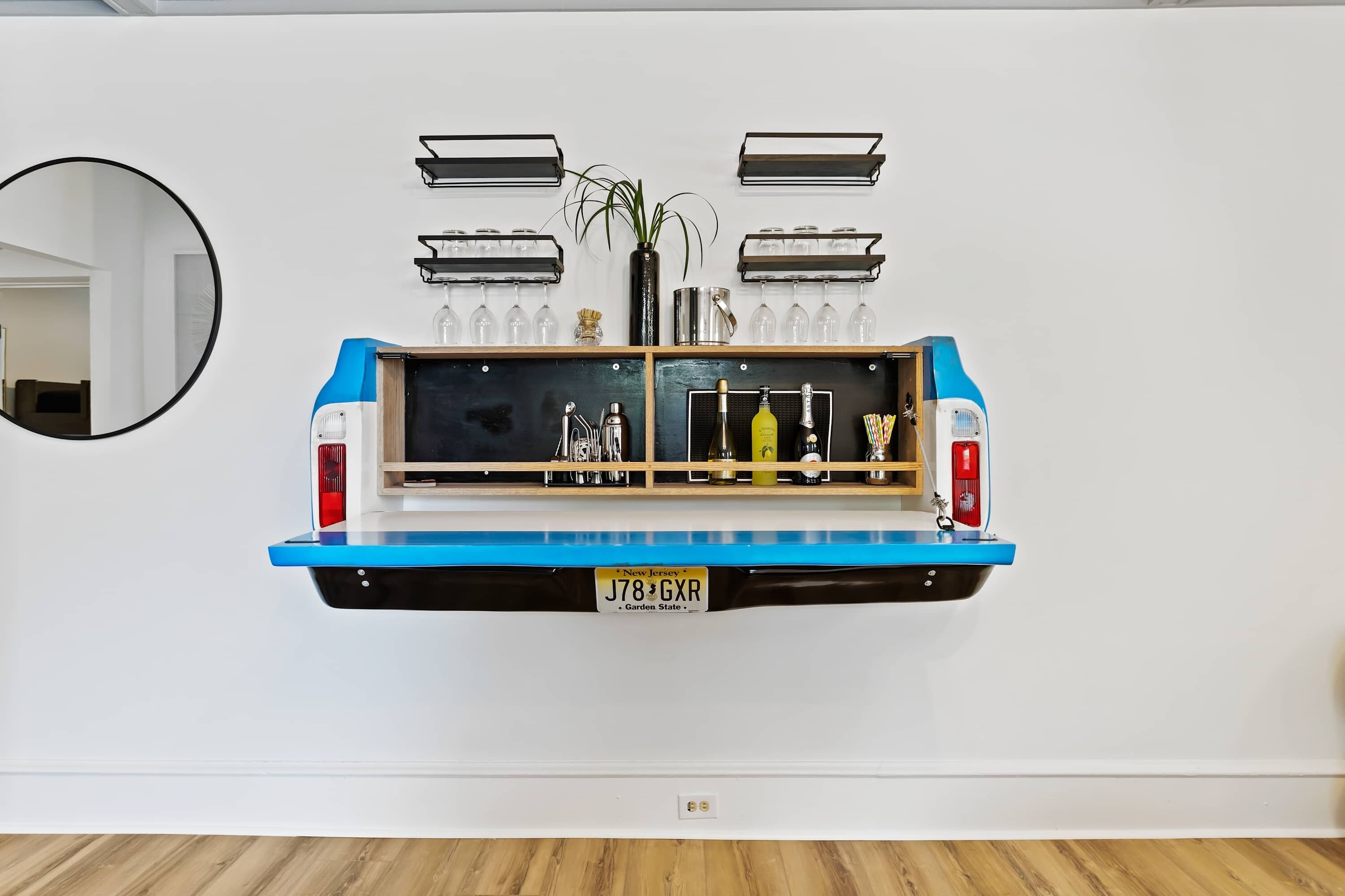 A blue and black truck bed mounted on a white wall, with a license plate reading "J78 GXR".