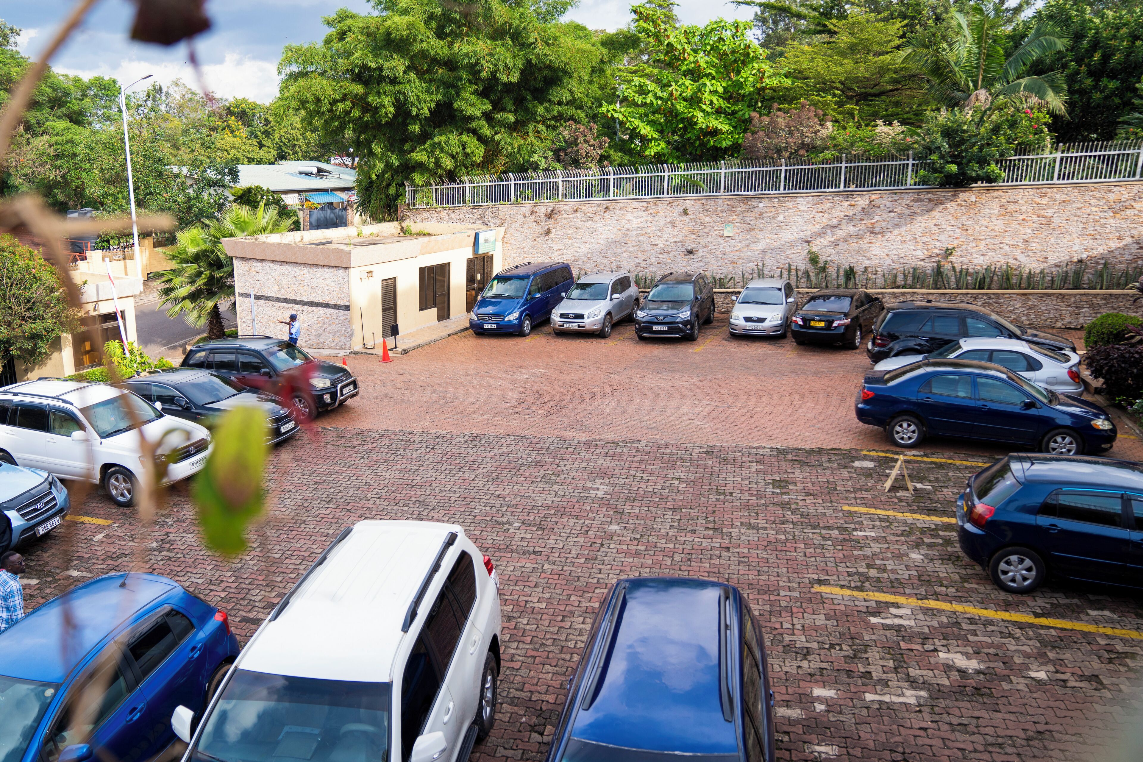 A parking lot with multiple cars and a building with a small entrance.