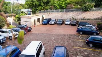 A parking lot with multiple cars and a building with a small entrance.