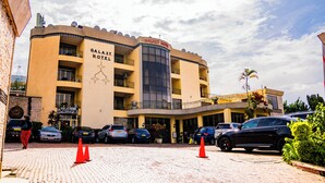 A hotel with a curved facade, multiple balconies, and a central entrance. - Galaxy Hotel (Kigali)