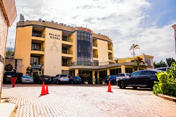 A hotel with a curved facade, multiple balconies, and a central entrance. - Galaxy Hotel (Kigali)
