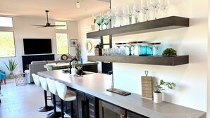 A modern kitchen with a bar area, built-in bar stools, and a wine rack on the wall. - 2 King Ensuites Elevated Views Spa Amenities at Sedona Sky (Sedona)