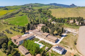 Uma grande propriedade com vários edifícios, piscina e painéis solares.