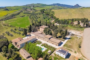 Una extensa propiedad con varias construcciones, piscina y paneles solares.