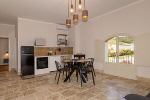 A kitchen with a dining area, a refrigerator, and a window with a view.