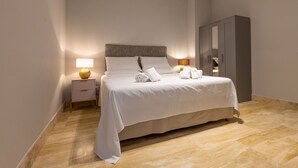 A hotel room with a bed, nightstand, lamp, and wardrobe. - Borgo Ariano 19 – Apartment with pool (Volterra)