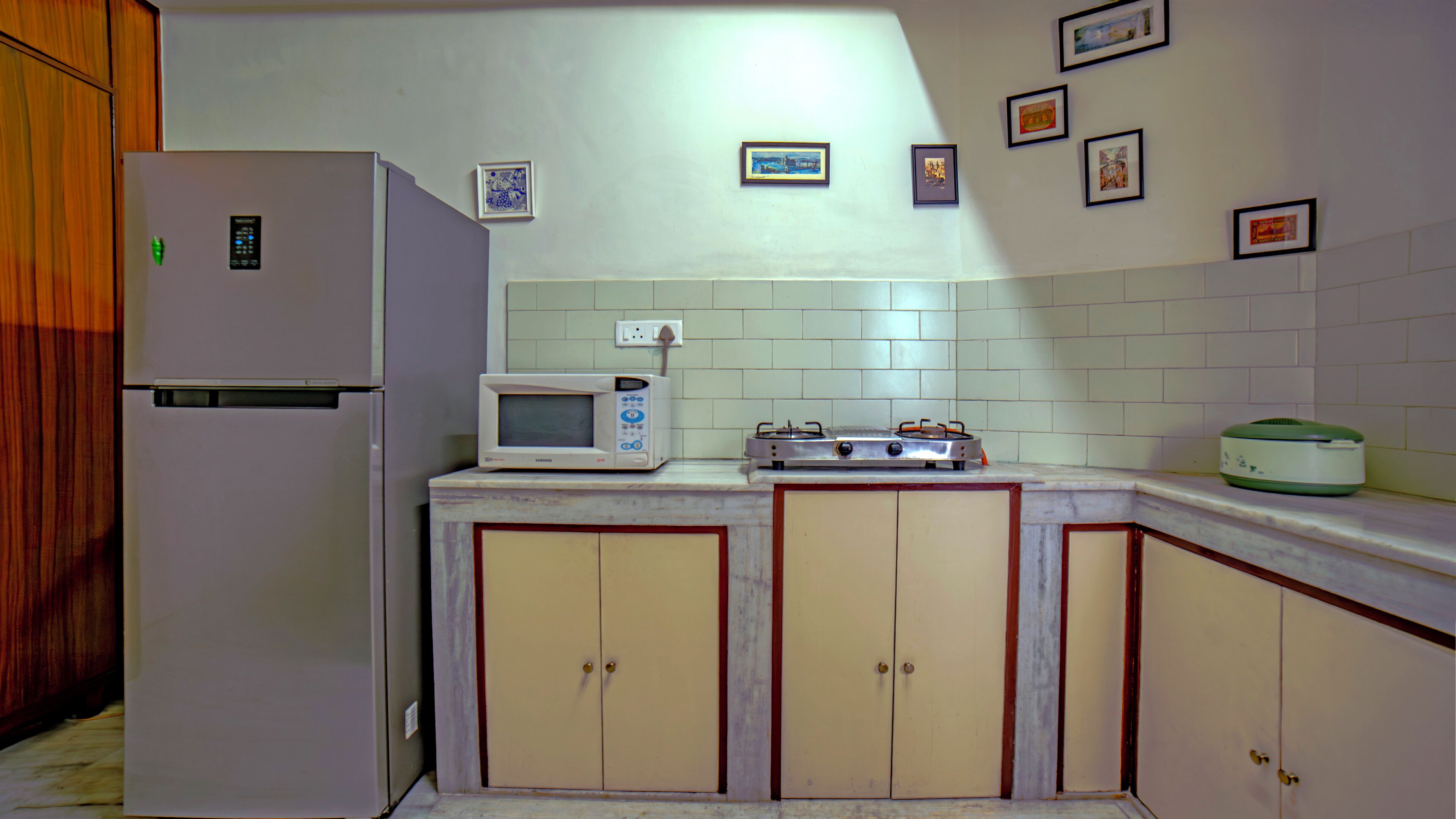 Una cocina equipada con refrigerador, microondas, estufa y alacenas.