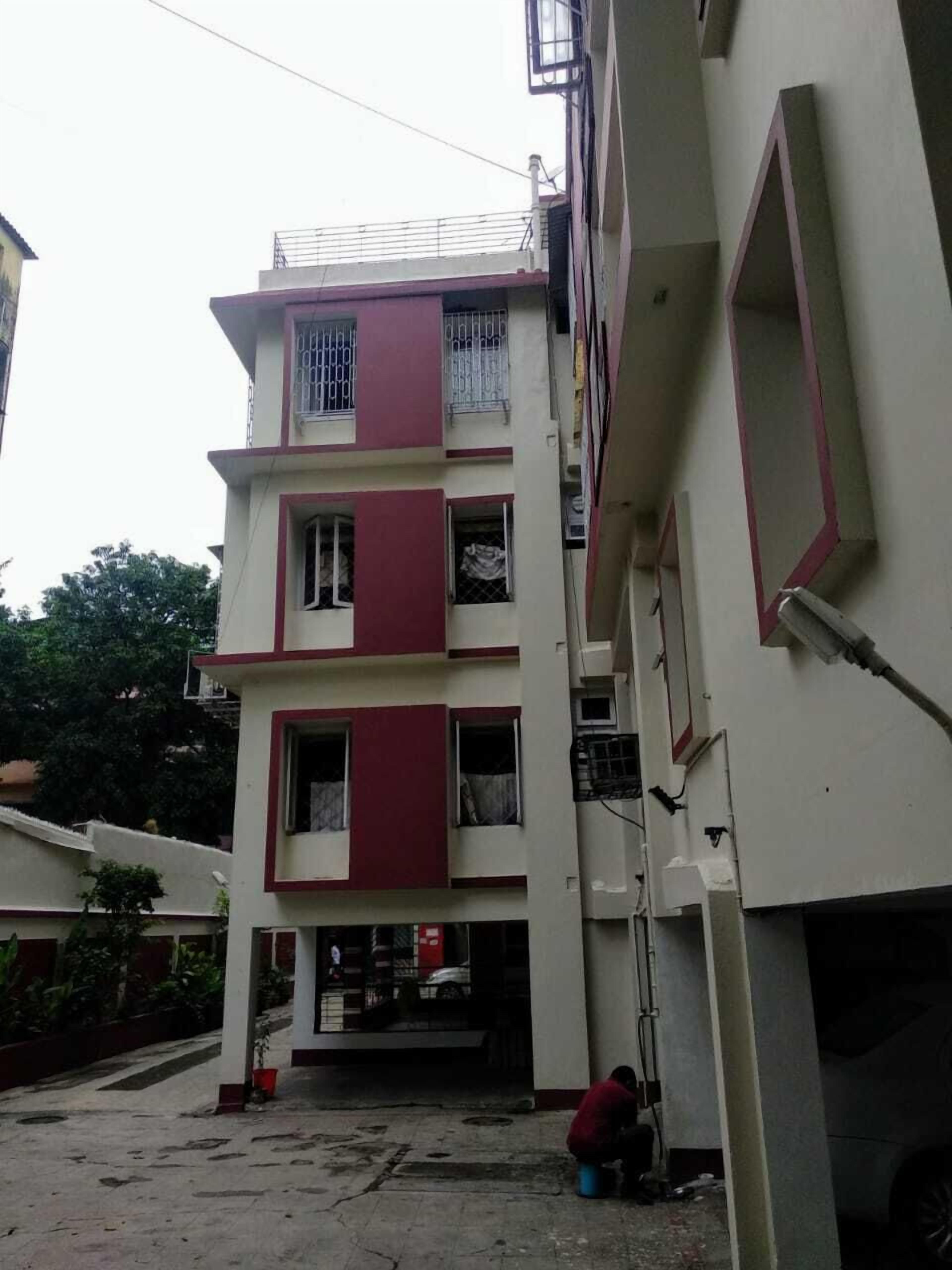 Un edificio de varios pisos con fachada plana, ventanas grandes y un balcón.