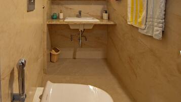 Een badkamer met toilet, wastafel en douche.