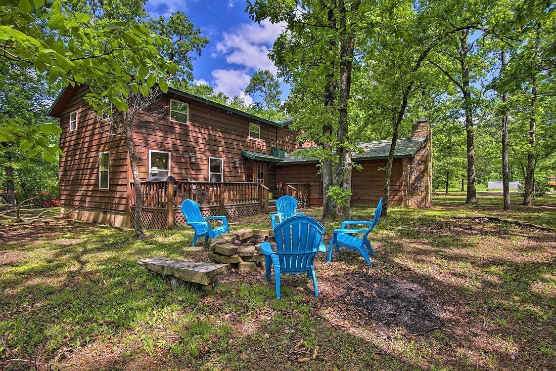 A rustic log cabin with a deck and outdoor seating area.