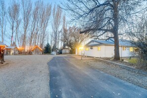 A residential street with houses, a paved road, and bare trees. - Farmhouse w/ Horse Corral Near Wind River Arena (Rigby)