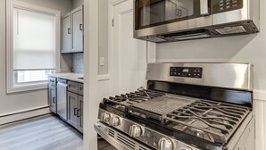 Une cuisine équipée d’une cuisinière, d’un four à micro-ondes et d’un four, le tout en acier inoxydable.