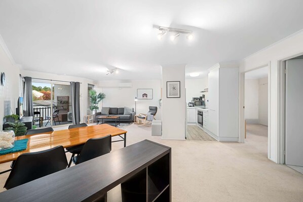 A modern apartment with a dining area, living room, and kitchen.