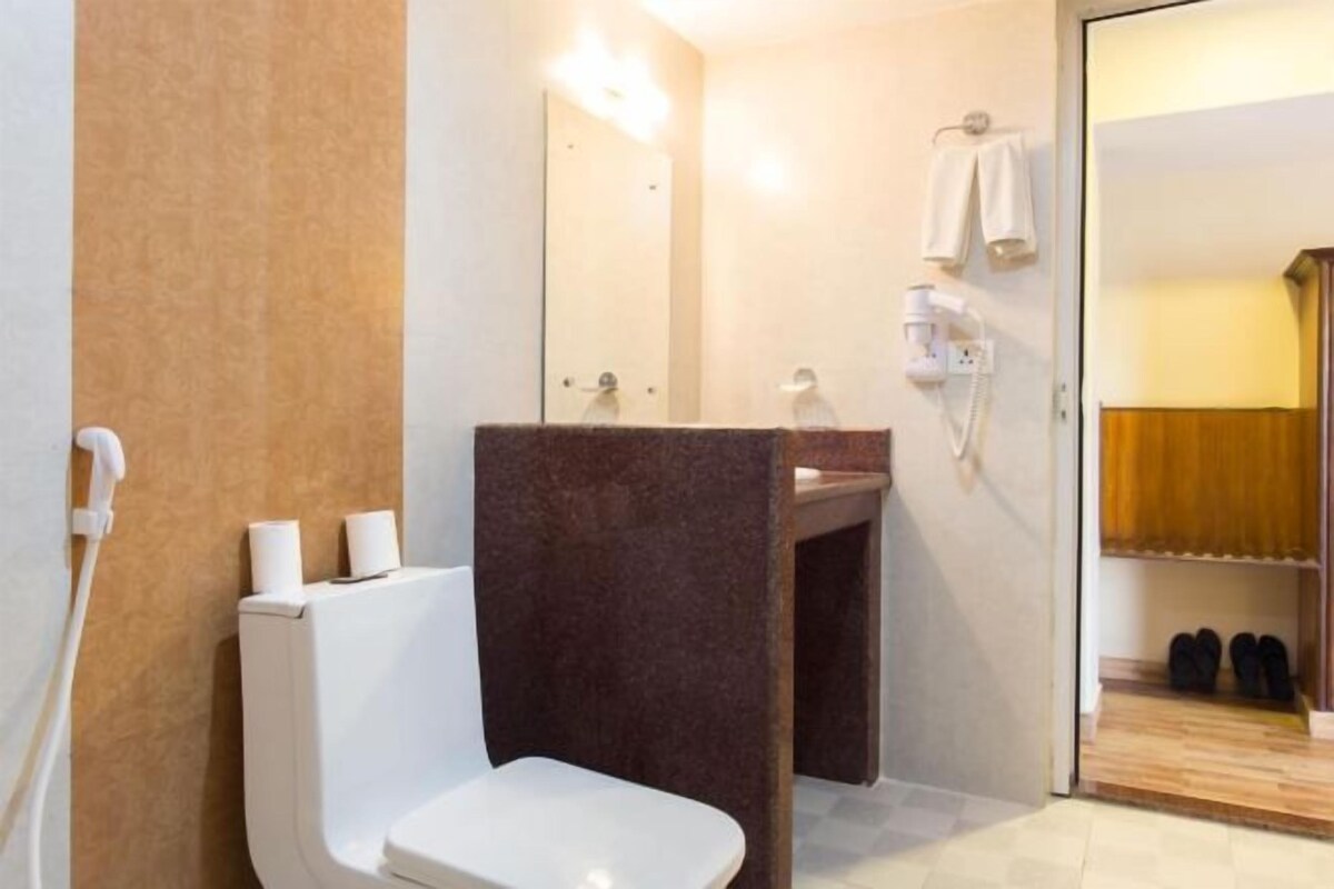 A bathroom with a toilet, sink, and shower area.