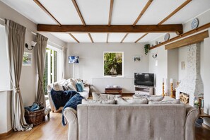 Una sala de estar acogedora con un sofá, televisor y chimenea.