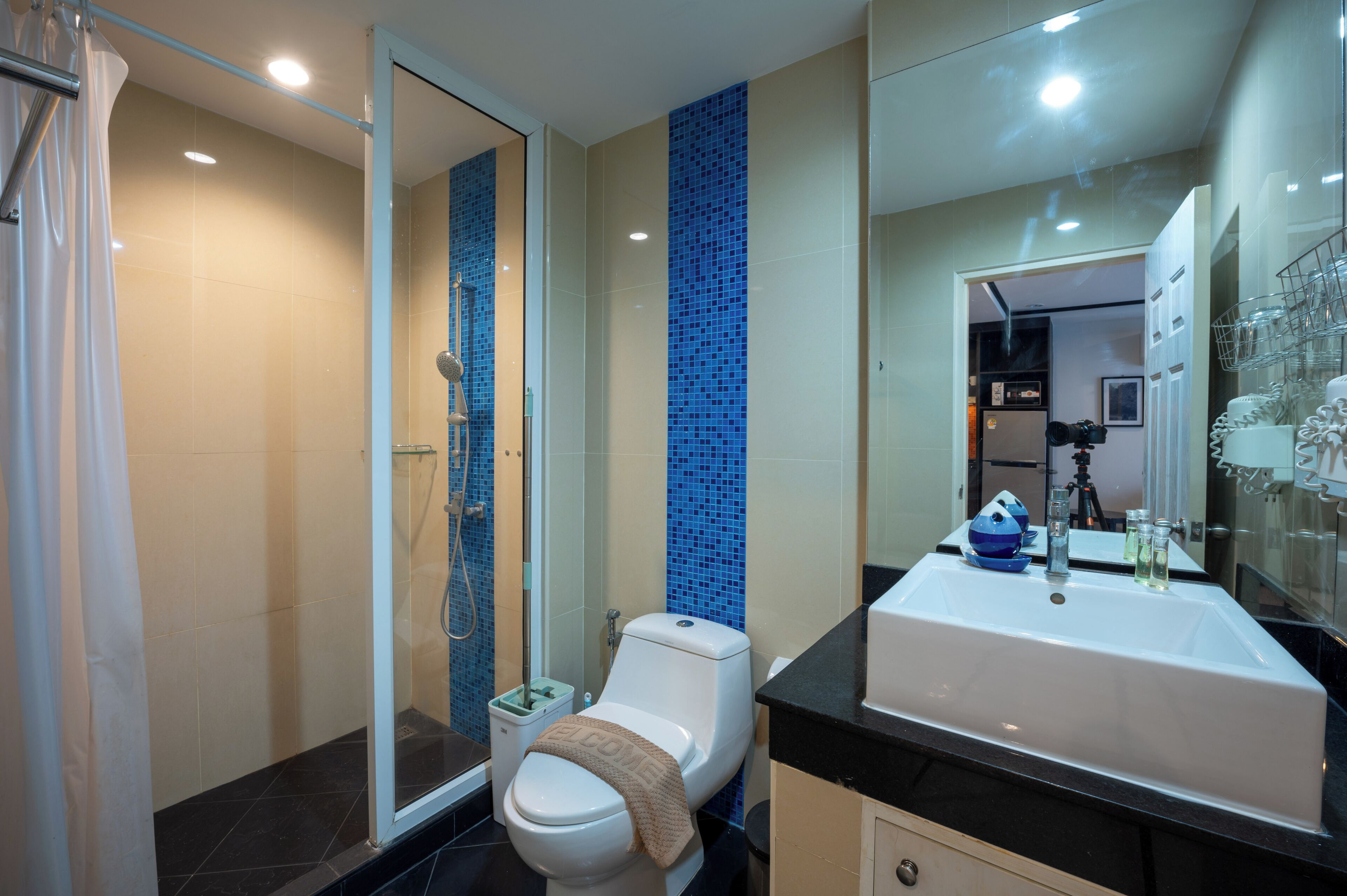 A modern bathroom with a shower, toilet, and sink.