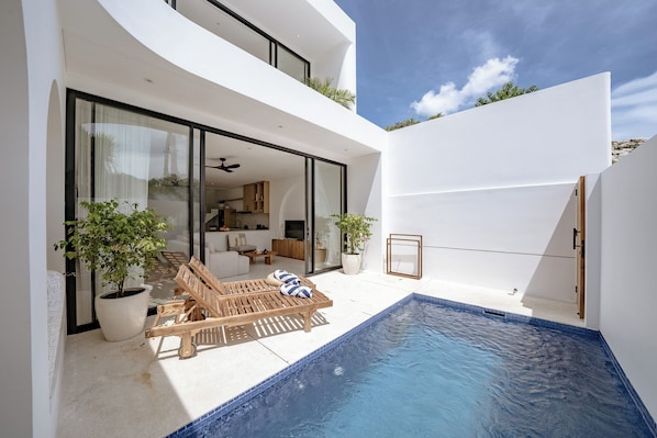 Enjoy the outdoors from the pool and lounge chair in this home's spacious living area.