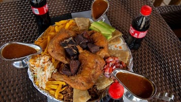 A large platter with various foods including fried chicken, fries, and coleslaw, accompanied by condiments.