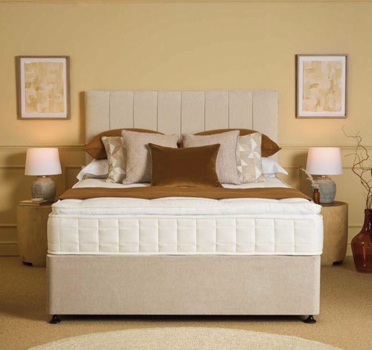 A bed with a headboard, two bedside tables, and two lamps.