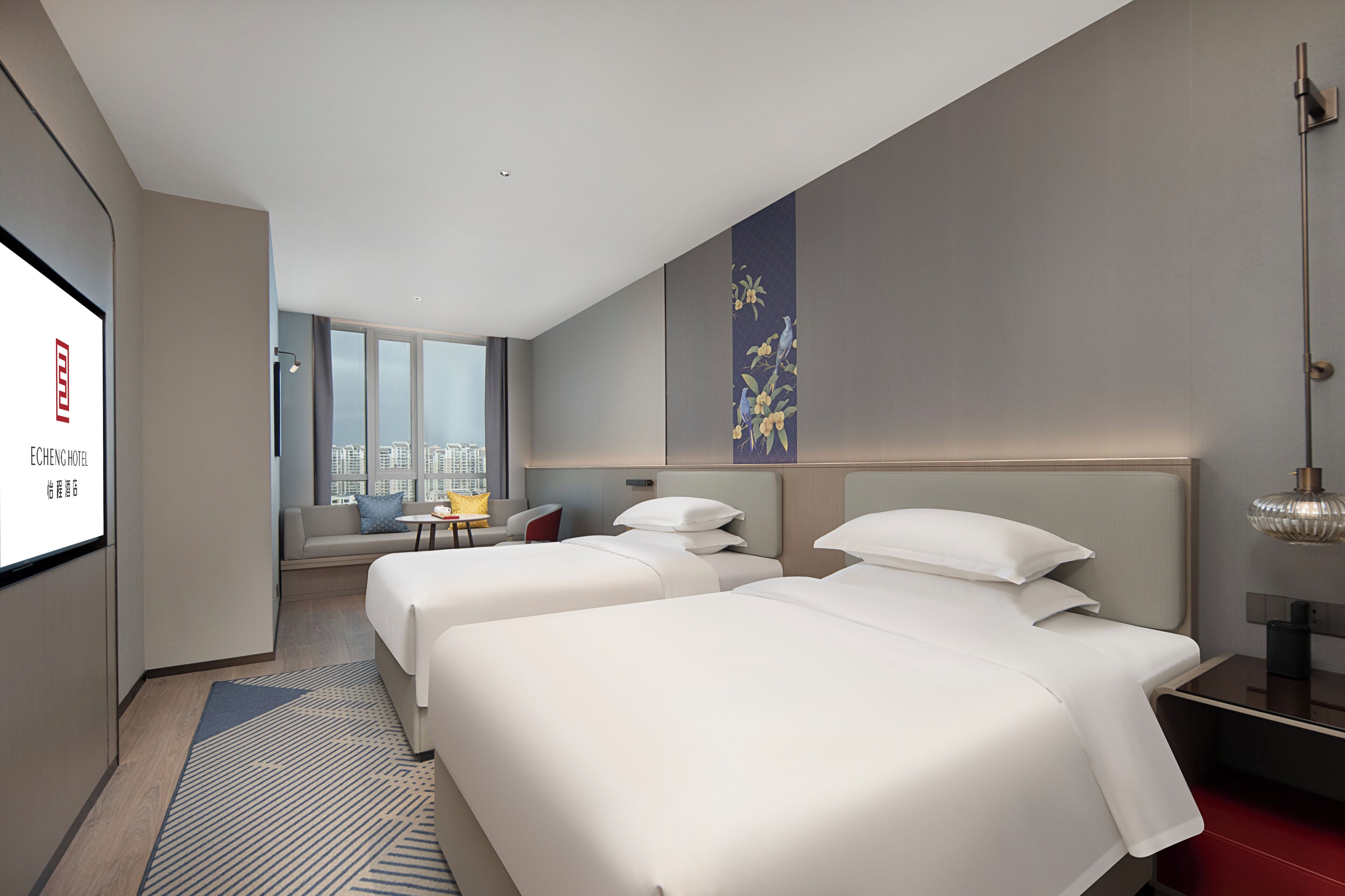 A hotel room with two beds, a sofa, a small table, and a city view.