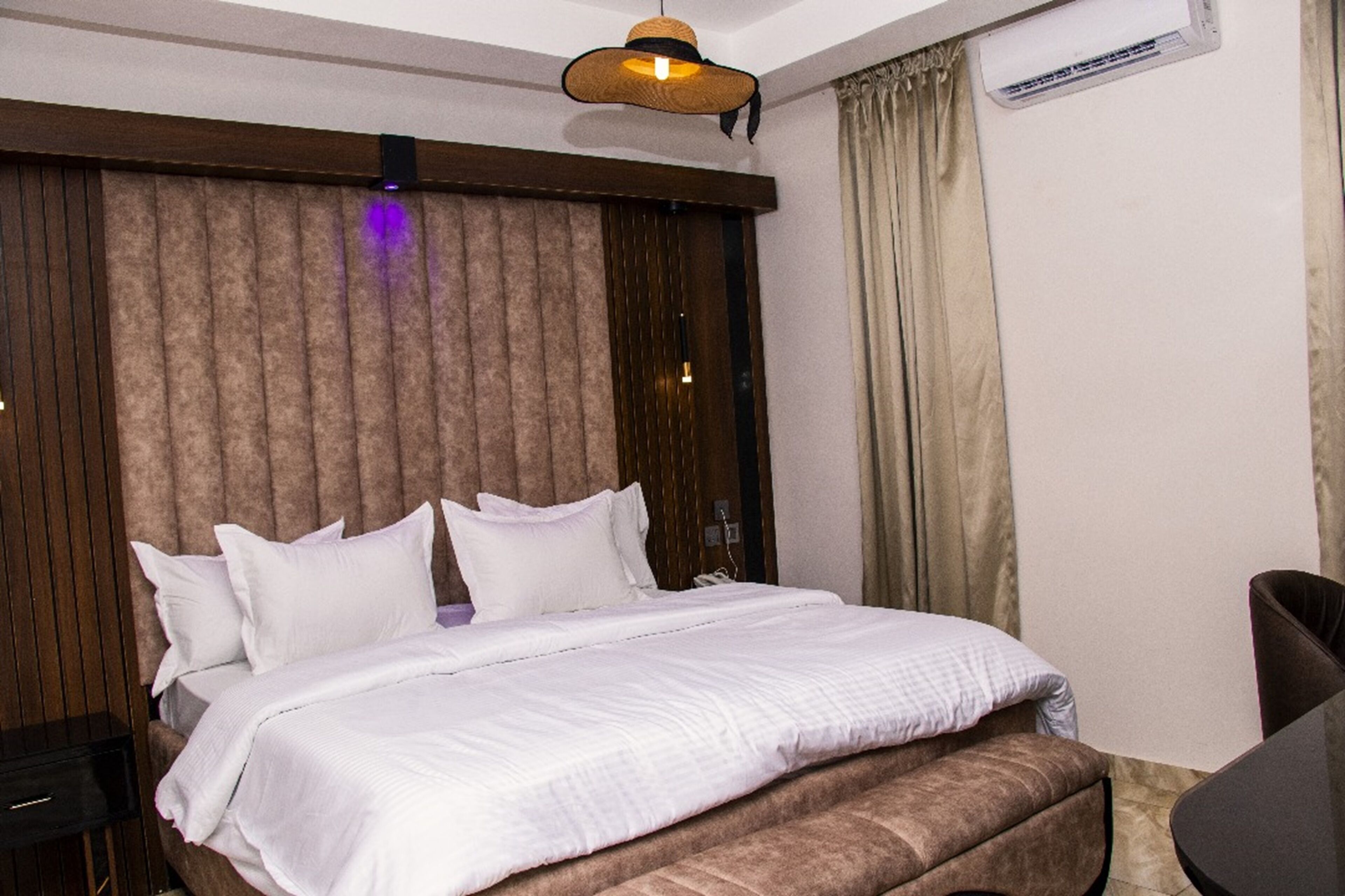Una habitación de hotel con una cama grande, un escritorio y una silla.