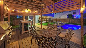 A wooden deck with outdoor furniture, a grill, and a swimming pool. - Coastal Retreat w/ Pool,  BBQ & Sunset Views | Beers and Sunshine by AvantStay (Port Aransas)