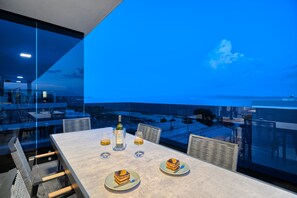 Enjoy a meal with a city view from this dining area featuring a large table and comfortable chairs.