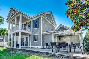 A two-story house with a covered patio and a balcony.