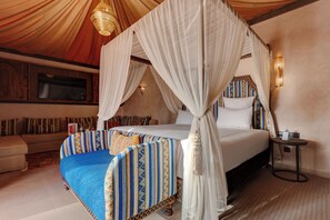 Una habitación con una cama, un sofá y una mesita.