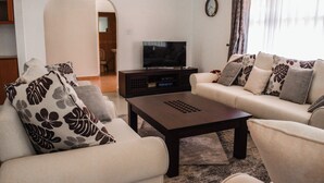 A living room with a sofa set, a coffee table, and a television. - Oleandar (Athi River)