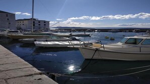Ein Yachthafen mit mehreren Schiffen, ein klarer Himmel und ein Gebäude im Hintergrund.