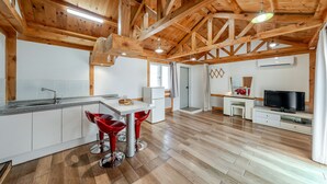 Una cocina moderna con encimera de granito, pileta de acero inoxidable y taburetes rojos.