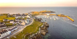 A coastal town with a marina, houses, and a prominent lighthouse.