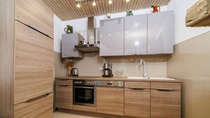 A compact kitchen with wooden cabinets, a built-in oven, and a sink. - Adorable home with bubble bath (Bribir)