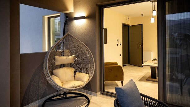 Ein modernes Interieur mit einem Hängesessel, einer Couch und einem Essbereich.