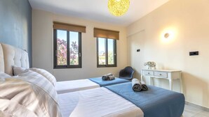 Een hotelkamer met twee bedden, een bureau en een stoel.
