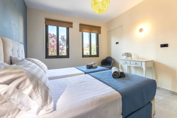 Een hotelkamer met twee bedden, een bureau en een stoel.