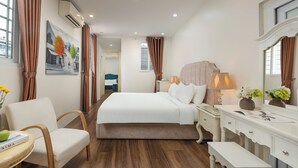 A hotel room with a large bed, a bedside table with a lamp, a chair, a desk, and a mirror. - Hanoi Milton Boutique Hotel  (Hanoi)
